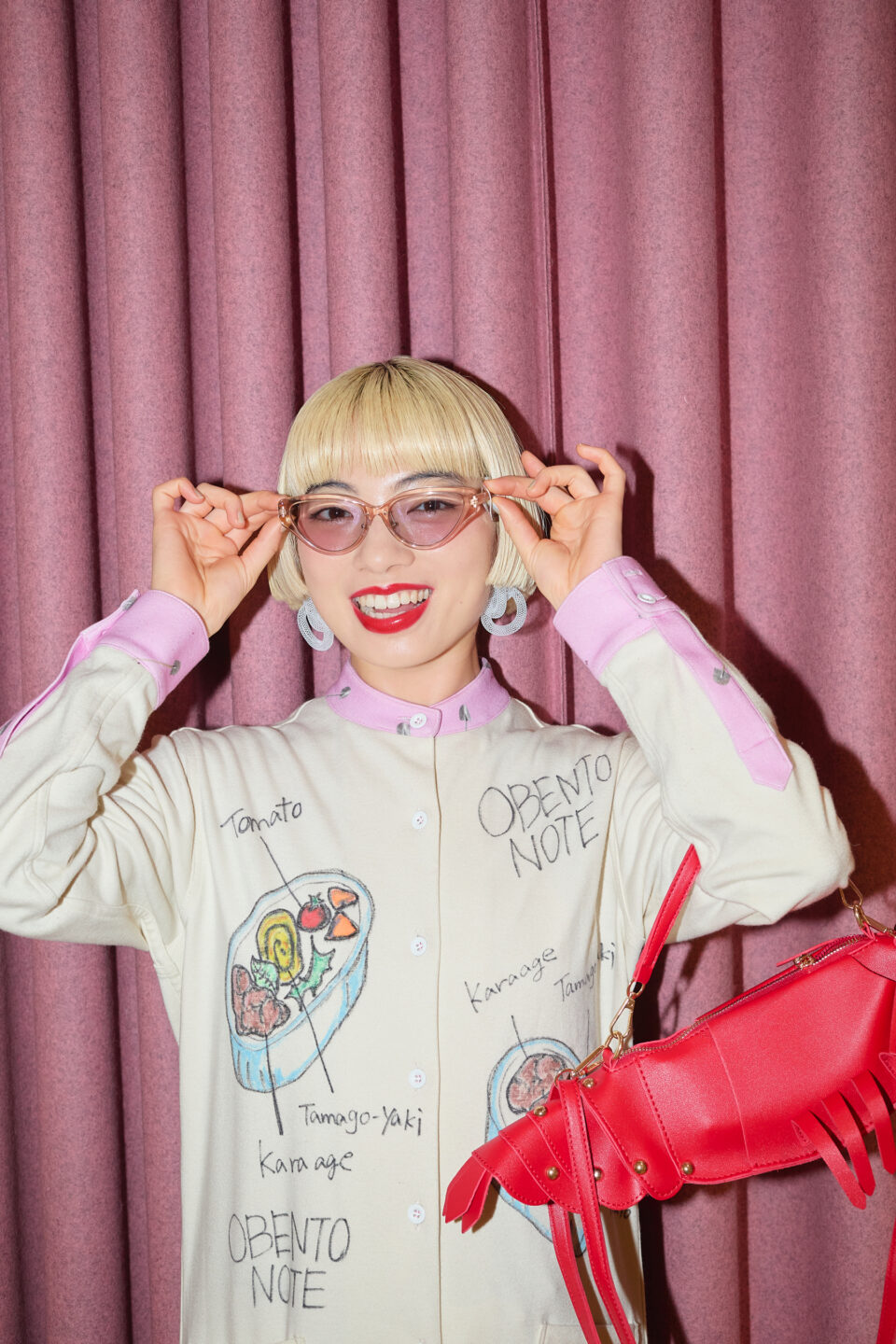 アオイヤマダさんがサングラスをかけピンクの背景で微笑むポートレート